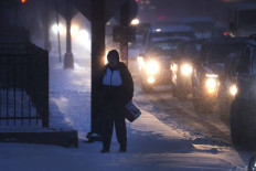 A pedestrian navigates a snow-covered sidewalk as temperatures hang in the single-digits on Dec. 22, 2022 in Chicago, Illinois. 