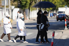 A man wearing a protective mask holds a picture frame of a loved one outside a funeral home, as coronavirus disease (COVID-19) outbreaks continue, in Shanghai, China, Dec. 23, 2022.