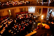Believers hold candles during a Christmas Mass at Immanuel Church in Jakarta on Dec. 24.