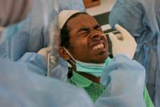 A health worker takes a swab from a Rohingya refugee to test for COVID-19 in Ladong, Aceh province on December 26, 2022. A broken-down boat carrying 57 Rohingya refugees landed on December 25 after a month at sea, police said.
