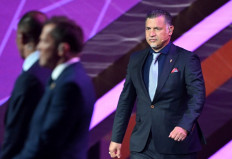 In this file photo taken on April 1, 2022, former Iranian footballer Ali Daei (right) arrives on stage during the draw for the 2022 World Cup in Qatar at the Doha Exhibition and Convention Center. Iran has sealed a jewellery shop and restaurant belonging to football legend Ali Daei, after he backed protesters' calls for strikes this week, local media reported on December 5, 2022.
