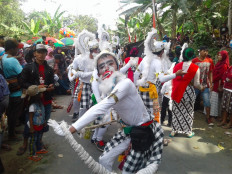Pluralistic parade: A youth dressed as Hanoman from the Sanskrit epic Ramayana, with a black-and-white sarong ubiquitous to Balinese Hinduism, takes part in the Kunci Taon parade in Manado, North Sulawesi, which is predominantly Christian. (Wikimedia Commons/Binti Dapubiwaha)