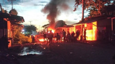 Local residents block and set up fires on a trans-national highway heading to PT Indonesia Weda Bay Industrial Park (IWIP) mining company in North Maluku on Dec. 25, 2022, following a clash.