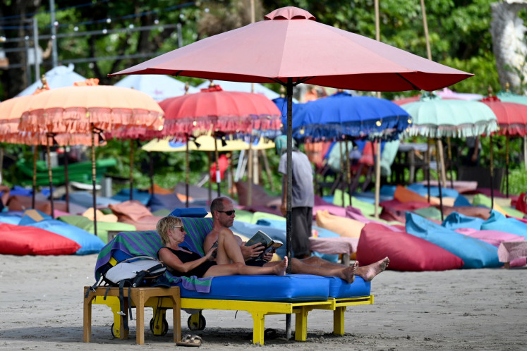 Foreign tourists relax on a beach in Seminyak, Badung, Bali, on Dec. 7, 2022.