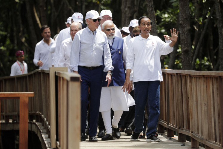 President Joko “Jokowi” Widodo (right) gestures as United States President Joe Biden (front, left), German Chancellor Olaf Scholz (back, left), Indian Prime Minister Narendra Modi (back, center) and other leaders walk together on Nov. 16, 2022, during a tree planting event at the Taman Hutan Raya Ngurah Rai Mangrove Forest, on the sidelines of the G20 summit in Nusa Dua, Bali.