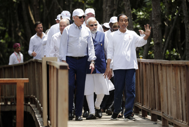 President Joko “Jokowi” Widodo (right) gestures as United States President Joe Biden (front, left), German Chancellor Olaf Scholz (back, left), Indian Prime Minister Narendra Modi (back, center) and other leaders walk together during a tree planting event at the Taman Hutan Raya Ngurah Rai Mangrove Forest, on the sidelines of the Group of 20 Summit meeting in Nusa Dua, Bali, on Nov. 16, 2022.
