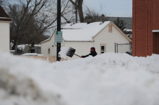  man clears his sidewalk along South Park Avenue on December 28, 2022 in Buffalo, New York. The historic Winter Storm Elliott dumped up to four feet of snow on the area leaving thousands without power and thirty confirmed dead in the city of Buffalo and the surrounding suburbs. 