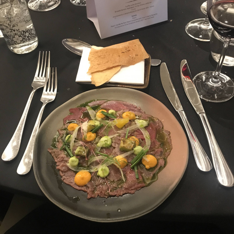A tender mélange of flavors: Tenderloin carpaccio with orange Cipriani sauce, avocado, fennel and Sardinia bread is paired with a glass of 2019 30 Mile Shiraz red wine from New South Wales. (JP/Tunggul Wirajuda)