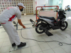 Inspecting emissions level: A mechanic at Astra Motor center repair shop in Cawang, East Jakarta, carries out an emissions test on a motorcycle. (JP/Wulan Kusuma Wardhani)