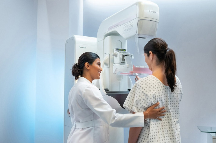 A health worker assists a patient during a mammography in this handout photo. 