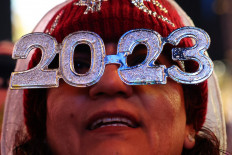 A person wears 2023 glasses while awaiting the ball drop on New Years Eve, in Times Square, New York City, on December 31, 2022. 
