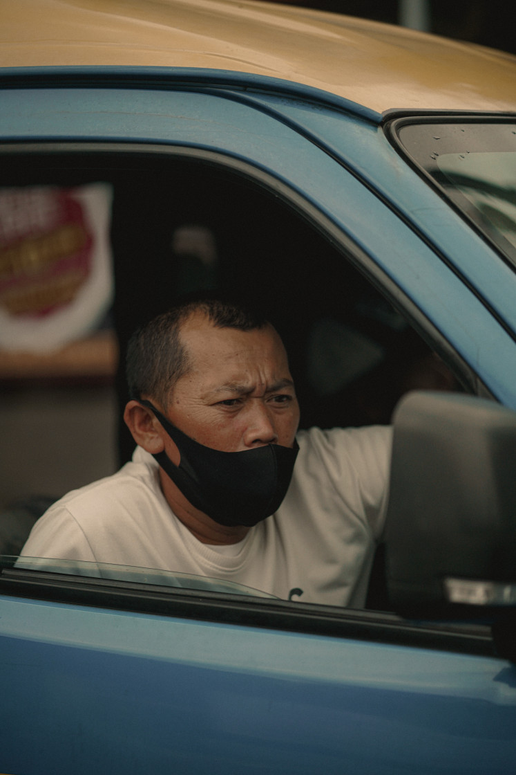 Lifeline: A  Margahayu Raya-Ledeng angkot driver in the middle of his trip. Alfrido, who grew up near the fleet's departure point, noted that the route is one of the finest examples of orderly conduct in the world of angkot in Bandung. Courtesy Farel Yesha/ Unsplash.