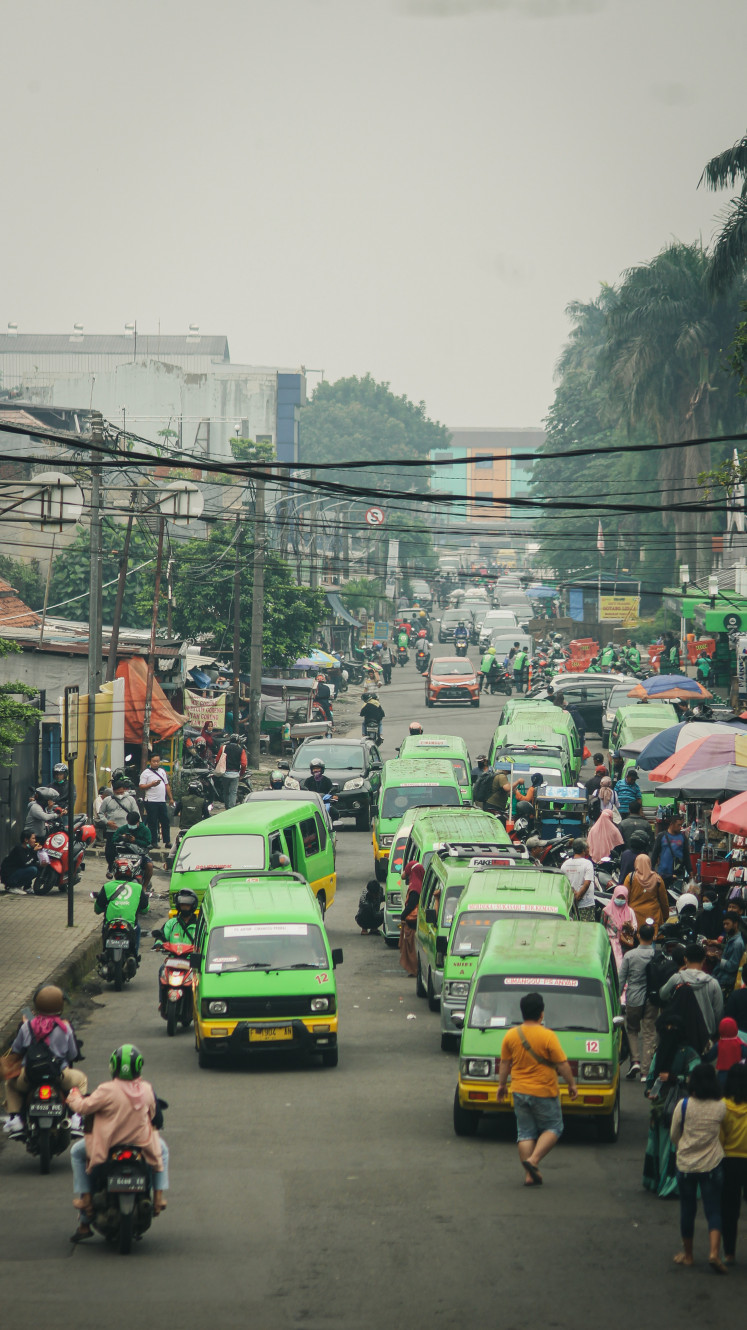 Pell-mell: A common scenery in Indonesia where angkot waited for customers, congregating in front of places of interest and causing traffic disruptions. Courtesy Ryan Dinata/ Unsplash.