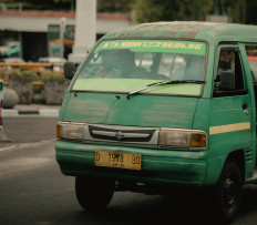 Phasing out: An angkot services a route that connects with the city's train station. People today tend to choose ride-hailing apps as their main mode of transportation over the angkot, leaving behind a meager portion of customers when compared with its golden age. 