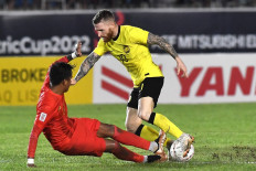 Thiha Htet Aung #17 (left) and Malaysia attacker MTuck Lee Andrew #10 (right) fight for the ball in Myanmar ’s 1-0 loss to Malaysia in the AFF Mitsubishi electric Cup 2022 Group match at Thuwanna Football Stadium, Yangon on December 21, 2022. 
