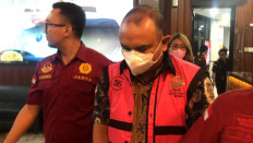Officers from the Attorney General’s Office flank Anang Achmad Latief as he is taken into custody on Jan. 4, 2022 on graft allegations.