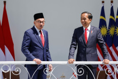 Malaysia's Prime Minister Anwar Ibrahim reacts while talking with President Joko “Jokowi“ Widodo during their meeting at the Presidential Palace in Bogor, Jan. 9, 2023. 