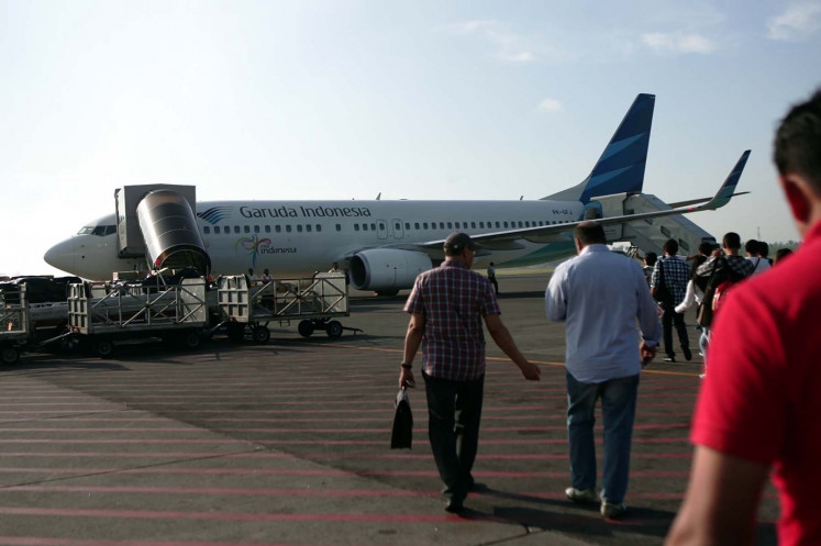 Passengers prepare to board a plan run by airline Garuda Indonesia at I Gusti Ngurah Rai airport in Bali on April 29, 2012. 