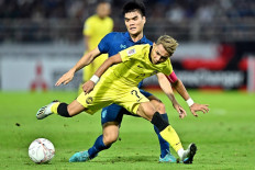 Thailand's Peeradol Chamrasamee (left) vies for the ball with Malaysia's Faisal Halim (right) during the AFF Mitsubishi Electric Cup 2022 semi-final football match between Thailand and Malaysia at Thammasat Stadium in Bangkok on January 10, 2023. 
