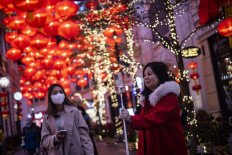 A woman takes a selfie in front of decorations in Hong Kong, China, on Jan. 19, 2023 ahead of the Lunar New Year of the Rabbit, which falls on January 22.
/ AFP