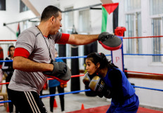 Palestinian girl Farah Abu Al-Qomsan, 15, trains with her coach, Osama Ayoub, inside the first women's boxing center in Gaza City January 17, 2023