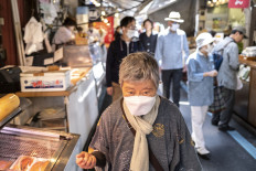 An elderly woman walks through a street market in Tokyo’s Tsukiji area on April 22, 2022. Japan, one of the world’s oldest societies, has in recent years been trying to encourage its people to have more children with promises of cash bonuses and better benefits.