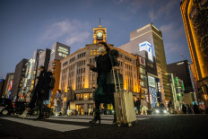 People cross a street in Ginza district of Tokyo on Jan. 24, 2023.