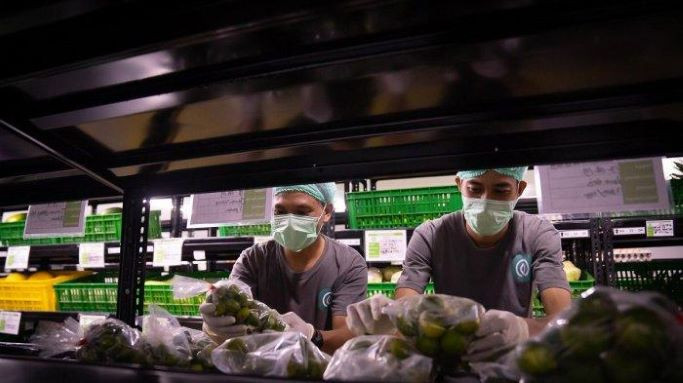 Employees arrange fruits and vegetables on Aug. 16, 2019, at a TaniHub distribution center in Kedung Halang, Bogor, West Java.