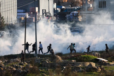 Israeli forces fire tear gas to disperse Palestinian demonstrators as they protest against the expropriation of Palestinian land on the northern entrance to the city of Ramallah, near the Jewish settlement of Beit El, in the occupied West Bank on Jan. 26.