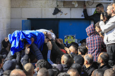 Palestinians carry the body of one of the nine victims killed during an Israeli raid on the West Bank's Jenin refugee camp as they begin a funeral procession in Jenin on Jan. 26, 2023. 