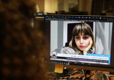 A woman in the Cypriot capital Nicosia, looks at a screen on on November 4, 2022, displaying an undated video of Iranian journalist Nazila Maroufian, who was arrested by the Iranian authorities on October 30, after she interviewed the father of Mahsa Amini.
