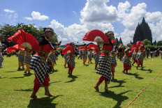 People dance in front of the Prambanan Temple in Yogyakarta on December 18, 2022.

