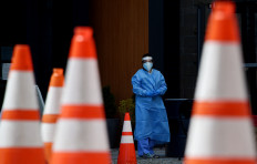 In this file photo taken on May 12, 2020 Healthcare workers wait for patients to be tested at a walk-in COVID-19 testing site in Arlington, Virginia, US.