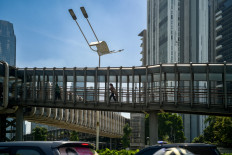 On the move: People use a pedestrian bridge to cross the road during the morning rush hour in Jakarta on Nov. 29, 2022. 