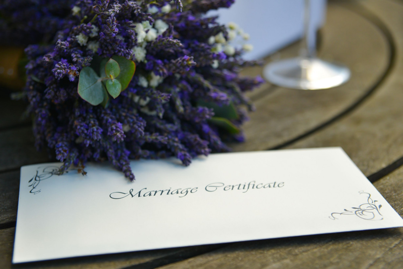 Bouquet on the table alongside a marriage certificate.