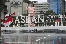 A woman poses with the newly installed logo of Indonesia’s 2023 ASEAN chairmanship at the Hotel Indonesia traffic circle in Jakarta on Jan. 29, when the government held an event to officially assume the rotating leadership of the regional bloc.