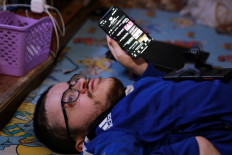 Amer Abo Nawas holds holds his mobile telephone which he used for recording his football match analysis to be posted on his social media page, at his home in Zarqa, Jordan, on January 23, 2023.