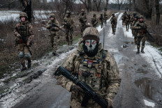 Ukrainian servicemen walk on the road toward their base near the frontline in the Donetsk region on Feb. 4, amid the Russian invasion of Ukraine.
YASUYOSHI CHIBA / AFP
