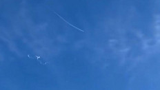 This still image taken from a cellphone video by Haley Walsh in Myrtle Beach, South Carolina, shows a suspected Chinese surveillance balloon after it was shot down (left) on February 4, 2023. 