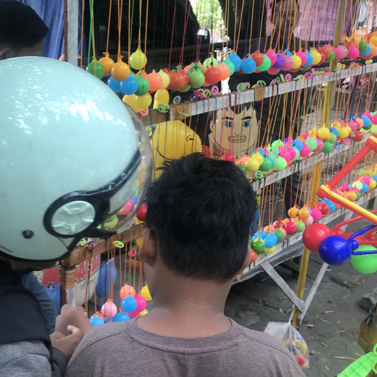 Choices: A mother and son ponder which 'lato-lato' to buy (JP/Tunggul Wirajuda)