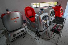 This picture taken on January 18, 2023 shows service robots developed by Tokyo-based robotics firm ZMP (L to R); a pair of single-seat mobility robots RakuRo, security robot PATORO, and delivery robot DeliRo at the company's service station in Tokyo.
“Excuse me, coming through,“ a four-wheeled robot chirps as it dodges pedestrians on a street outside Tokyo, part of an experiment businesses hope will tackle labour shortages and rural isolation.