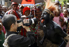 A Japanese tourist (left) photographs the betel-nut-stained tongue of a Waikondo warrior during the 50th Goroka cultural show on Sept. 16, 2006.