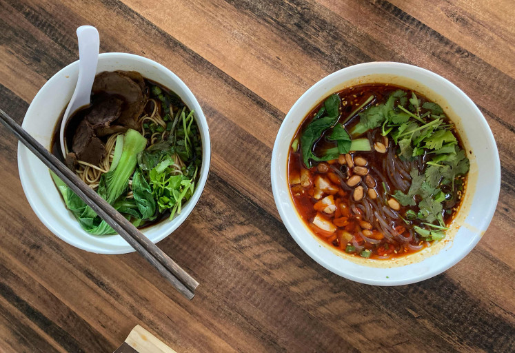 Earth and fire: Kedai Wanmin's beef soup served with wheat flour noodles (left) and spicy and sour soup served with sweet potato noodles. (JP/Anindito Ariwandono)