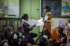 A teacher peruses materials written in the local Nage language at St. Clara preschool in Nagakeo regency, East Nusa Tenggara, on Feb. 9.