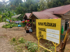 A yellow board reminds residents living in Marancar district in South Tapanuli regency, North Sumatra, about scheduled blasts by PT North Sumatra Hydro Energy (NSHE), the developer of a hydropower-plant project in Batang Toru, in this photo taken on December 9, 2022.