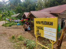 A yellow board reminds residents living in Marancar district, South Tapanuli regency, North Sumatra, about scheduled blasts by PT North Sumatra Hydro Energy (NSHE), the developer of a hydropower plant project in Batang Toru, in this file photo taken on Dec. 9, 2022.