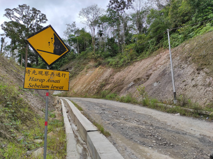 A yellow sign warns of falling debris on a service road leading to a concrete production facility owned by PT North Sumatra Hydro Energy (NSHE), near Batu Jomba Sipirok in South Tapanuli regency, North Sumatra. The photo was taken on Dec. 8, 2022.