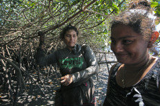 Elena Martinez and a friend, both residents of the town of Aserradores, Pacific Coast of Nicaragua, take a break while collecting black shells at a mangrove swamp to later sell them to tourists and restaurants in the area, on February 6, 2023. From a young age, Elena Martinez and other female residents of Aserradores, a small fishing community in eastern Nicaragua, learn to navigate the dense mangrove forest to extract a black mollusc from deep under the mud. Every few days, they leave home at dawn to row about two kilometers (1.2 miles) in a fishing boat to the mangrove, where they crawl through gnarly branches knee-deep in mud, digging for the delicacy by hand. While keeping food on the table, the women also help conserve the mangrove -- a natural barrier that harbors countless animal species and protects coastal settlements like their own from floods, tidal waves and hurricane winds.
