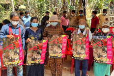 This picture released by Cambodia's Communicable Disease Control Department (CDCD) on Feb. 23, 2023, shows villagers posing with posters about H5N1 virus threats, in Prey Veng province.