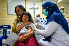 A student reacts while receiving the diphtheria vaccine at a Christian elementary school in Banda Aceh on Nov. 15, 2022.